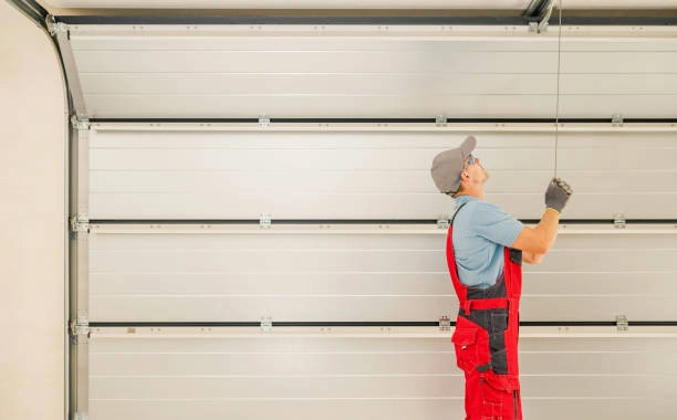 person pulling garage door with red suit -garage door installer