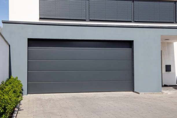 outdoor view of garage with grey door, grey house and road -garage door installer