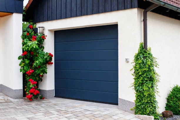 outdoor view of garage with blue door and 2 plants -cost for garage door installation