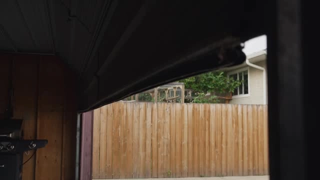 garage door indoor view looking outside, wooden fence outside -emergency garage door repair