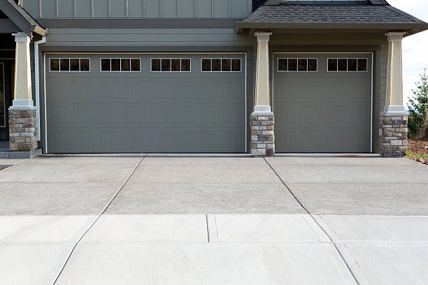 grey garage door with dark bricked color, light grey road outdoor view -garage door repair cost