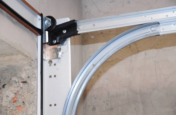 Garage door track and roller assembly on a concrete wall. -garage door seal