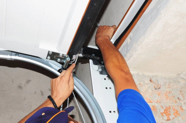 A person fixing or adjusting the garage door track and roller. -garage door seal