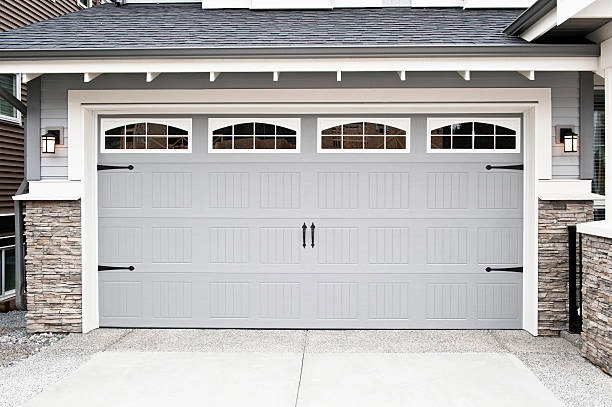 A classic white garage door with windows and stone accents. -modern garage doors