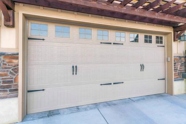 Beige garage door with small upper windows, black hardware accents. -garage door with windows