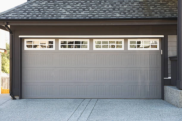 Gray garage door with rectangular paneling and top row windows. -garage door with windows